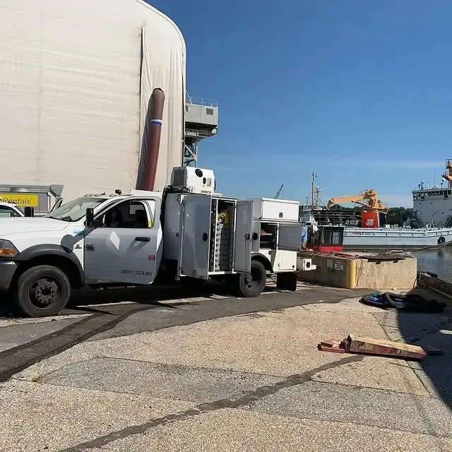 A white truck is parked in front of a large building