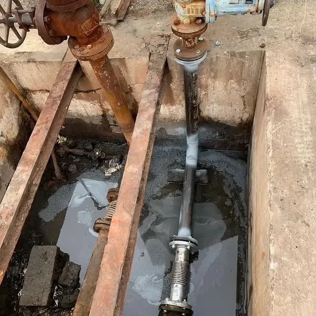 A pipe is connected to a valve in a hole in the ground.