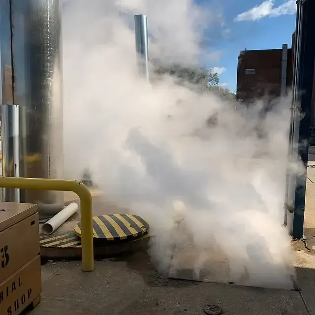 Smoke is coming out of a manhole cover that says chemical shop