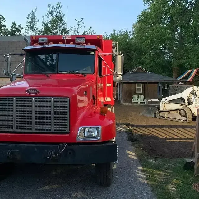 A red semi truck is parked in front of a house