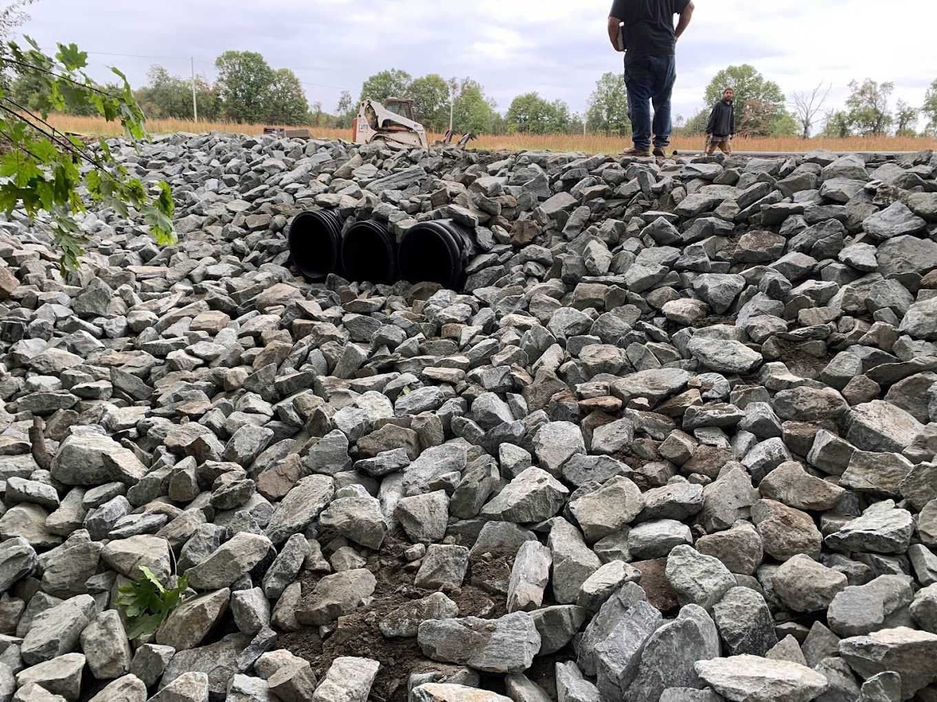 A man is standing on top of a pile of rocks.