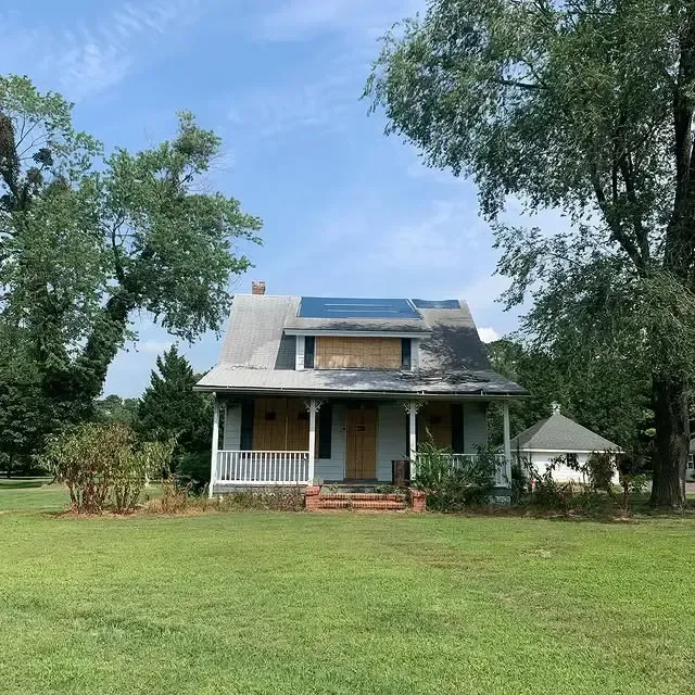 A house with a porch and solar panels on the roof