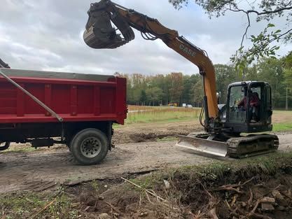 An excavator is loading dirt into a dump truck.