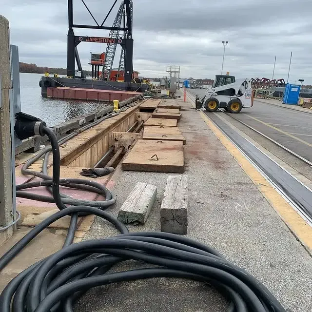 A hose is laying on the ground next to a dock