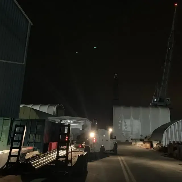 A truck is parked on the side of the road at night
