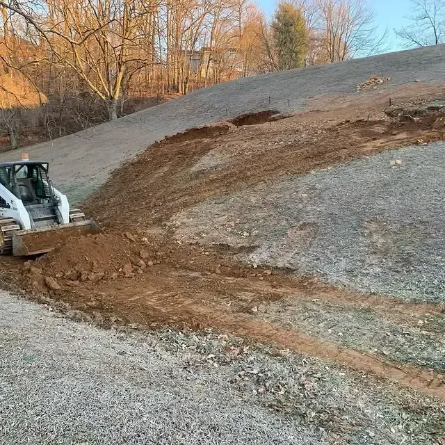 A bulldozer is moving dirt on a hill.