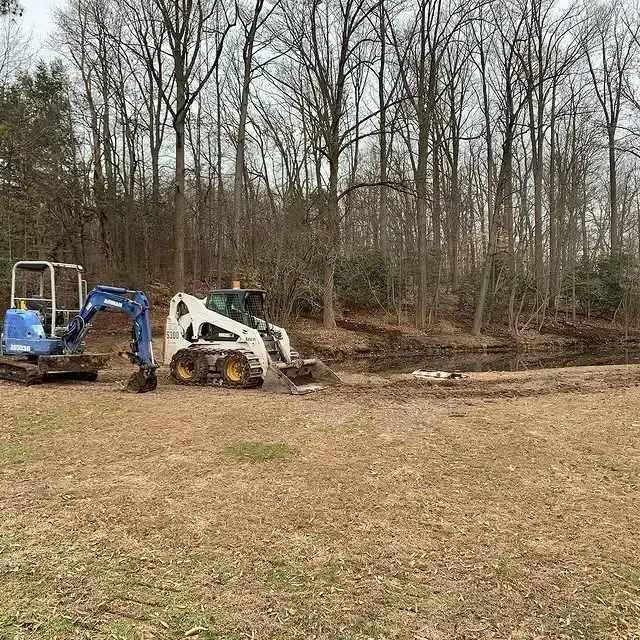 A bulldozer and an excavator are working in a field.