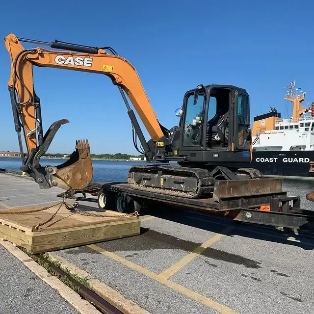 A case excavator is parked next to a coast guard boat