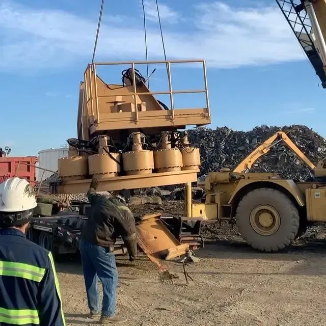 A man wearing a hard hat is standing in front of a large yellow truck