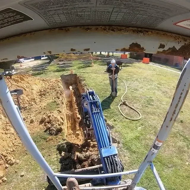 A man is digging a hole with a shovel in a field