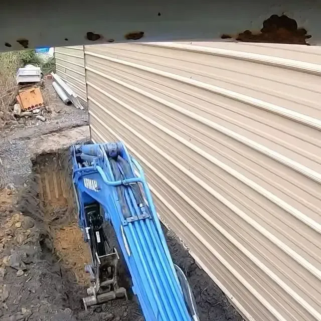 A blue crane is digging a hole in front of a building