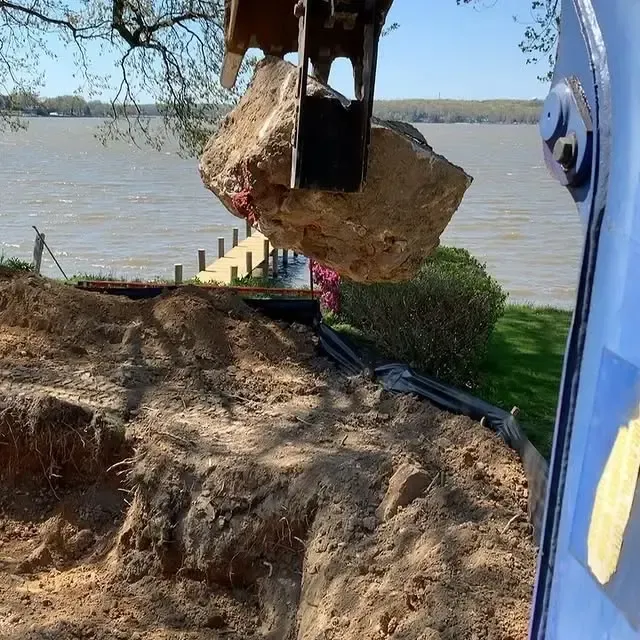 A large rock is being lifted out of the ground by a machine