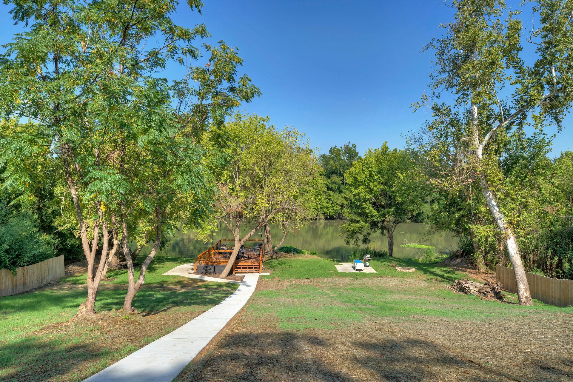 A path leading to a picnic area surrounded by trees.