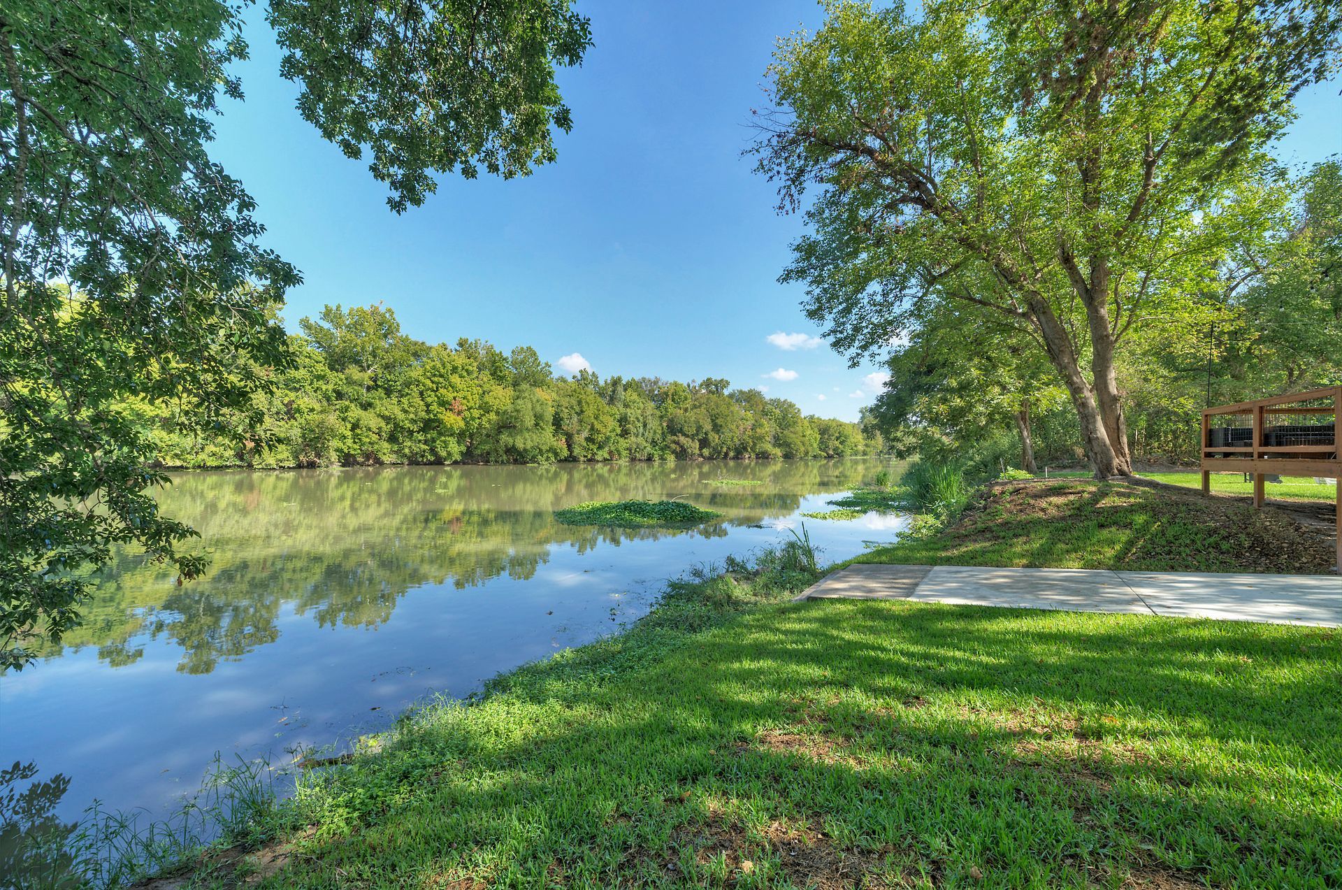 A river surrounded by trees and grass on a sunny day