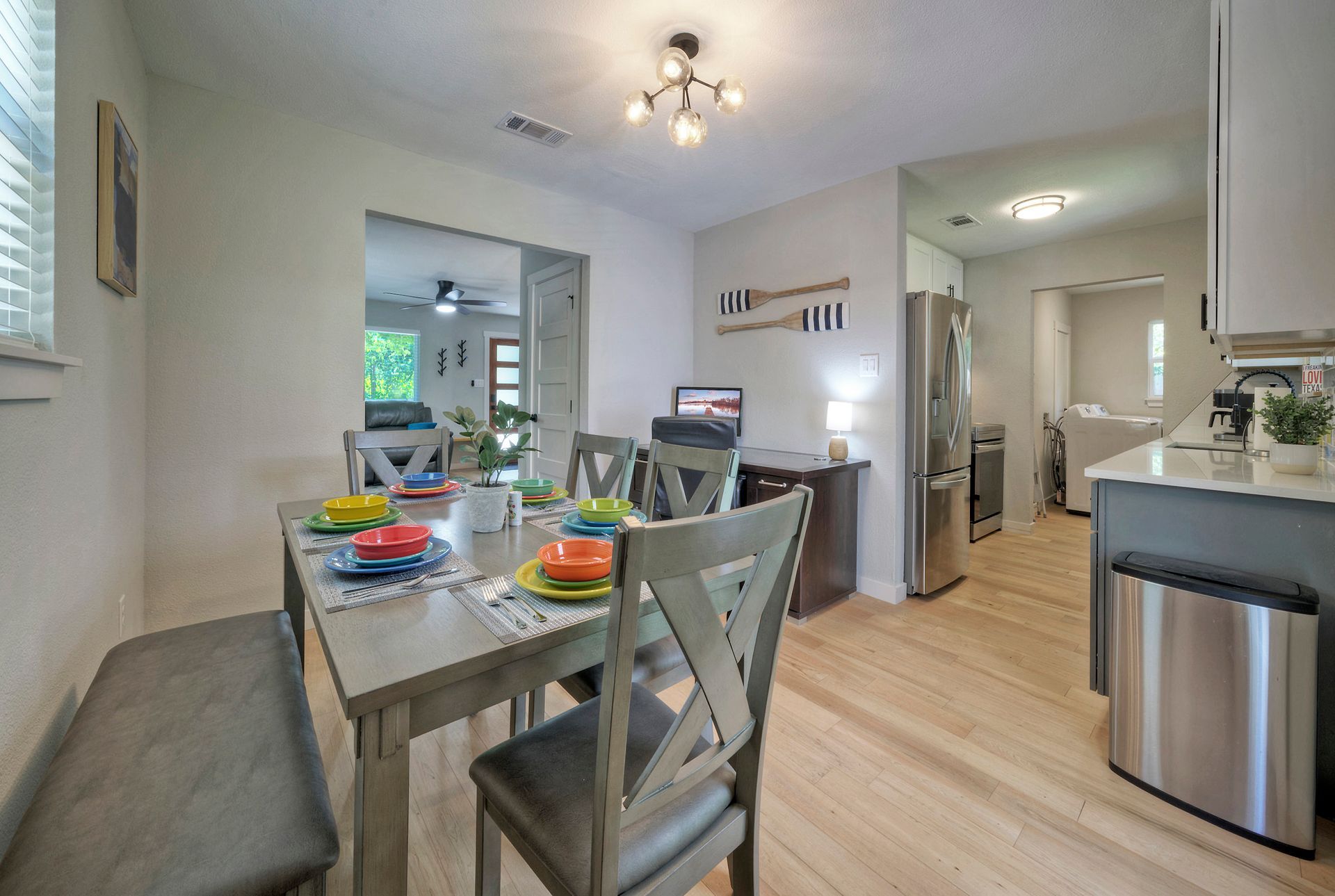 A dining room with a table and chairs and a bench.