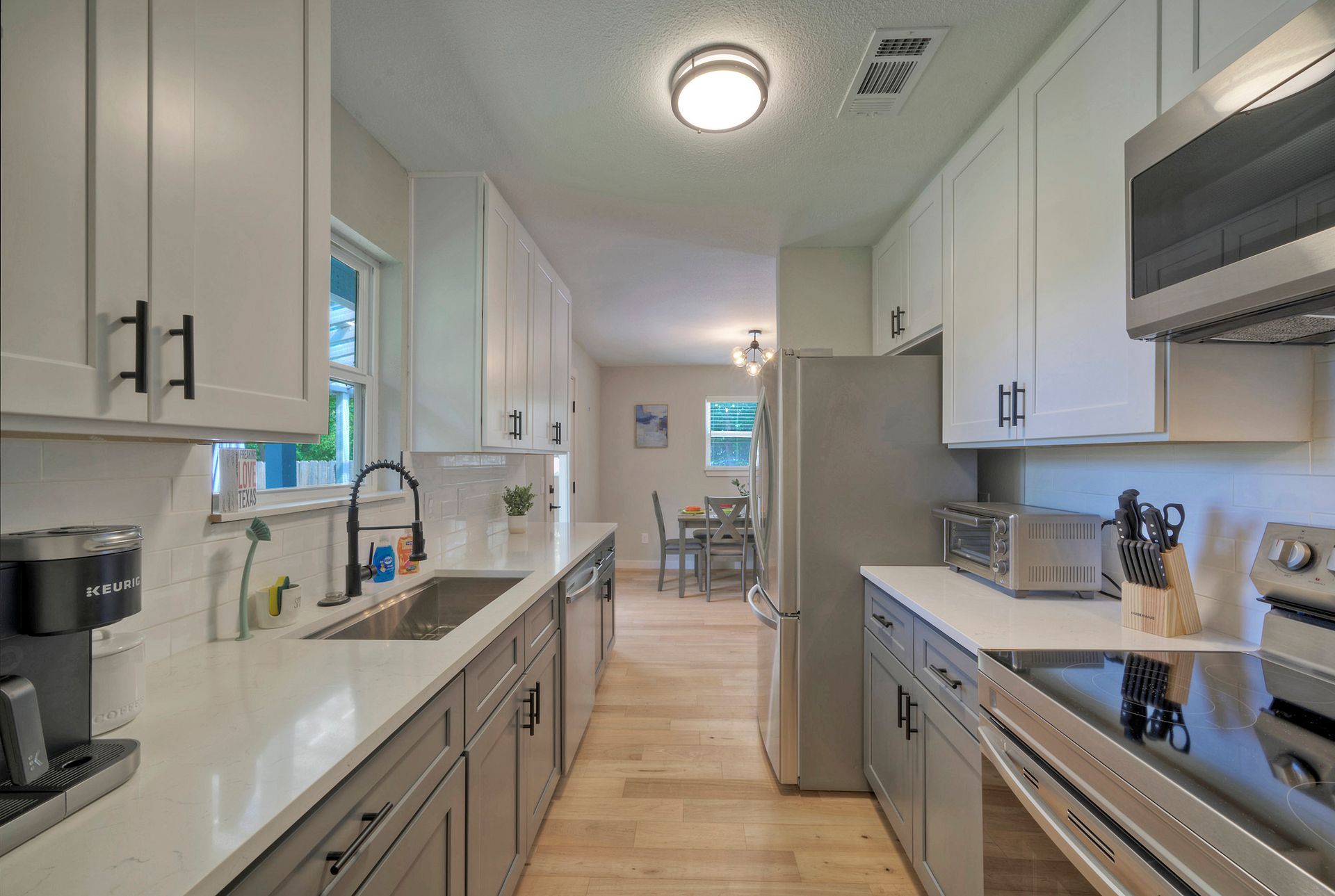 A kitchen with white cabinets and stainless steel appliances