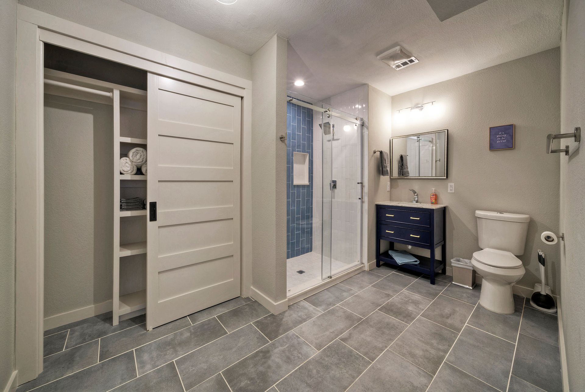 A bathroom with a toilet , sink and shower.