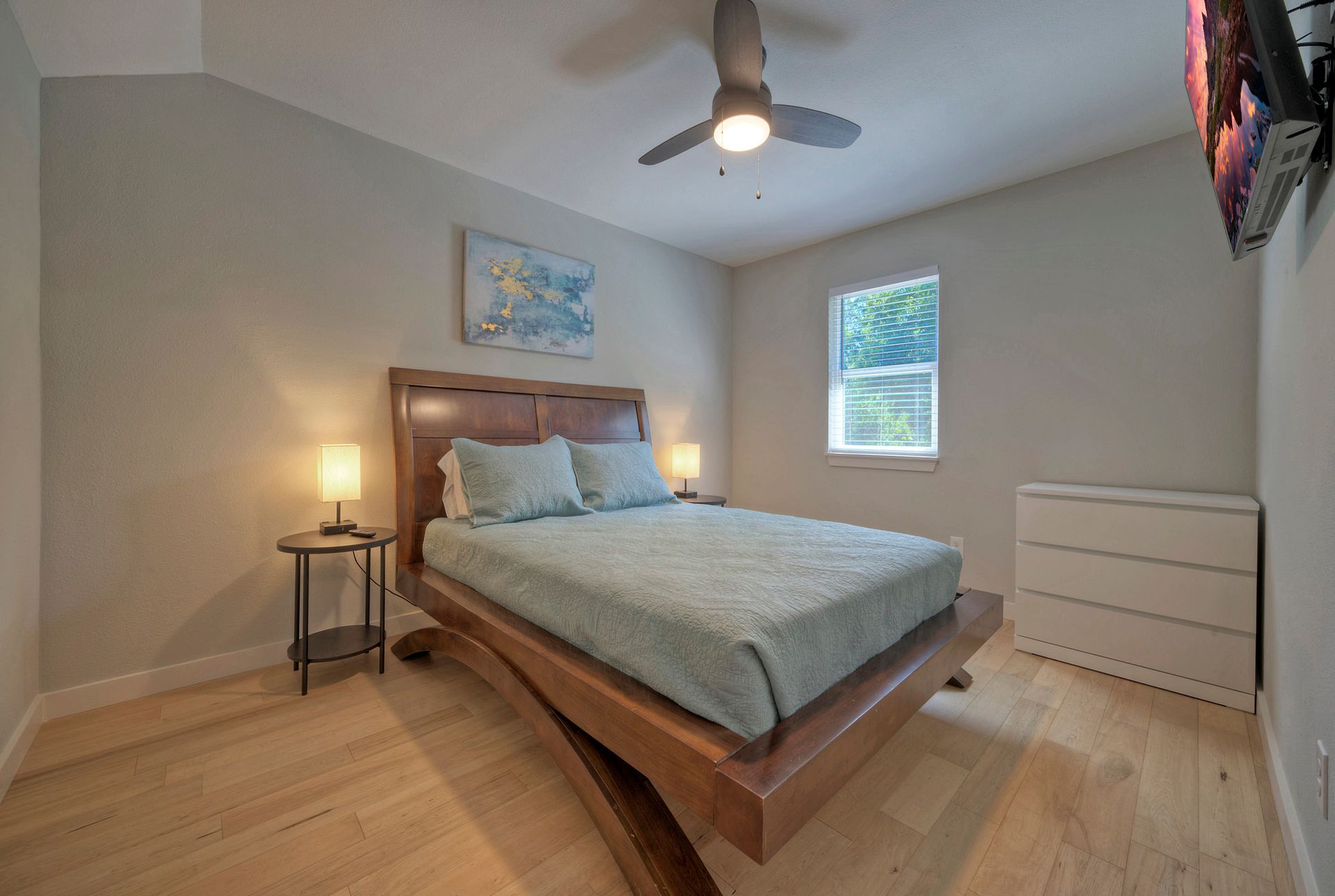 A bedroom with a king size bed and a ceiling fan.
