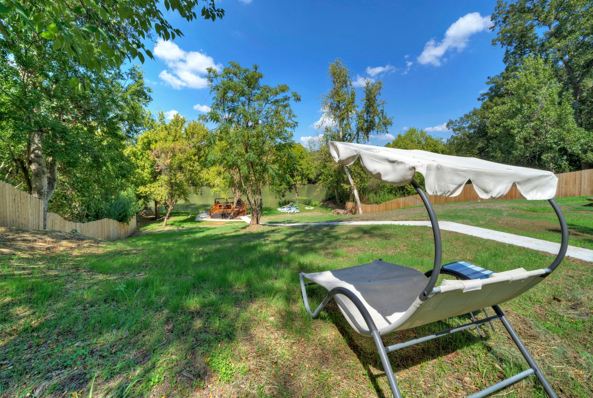 A lawn chair with a white canopy is sitting in the grass.