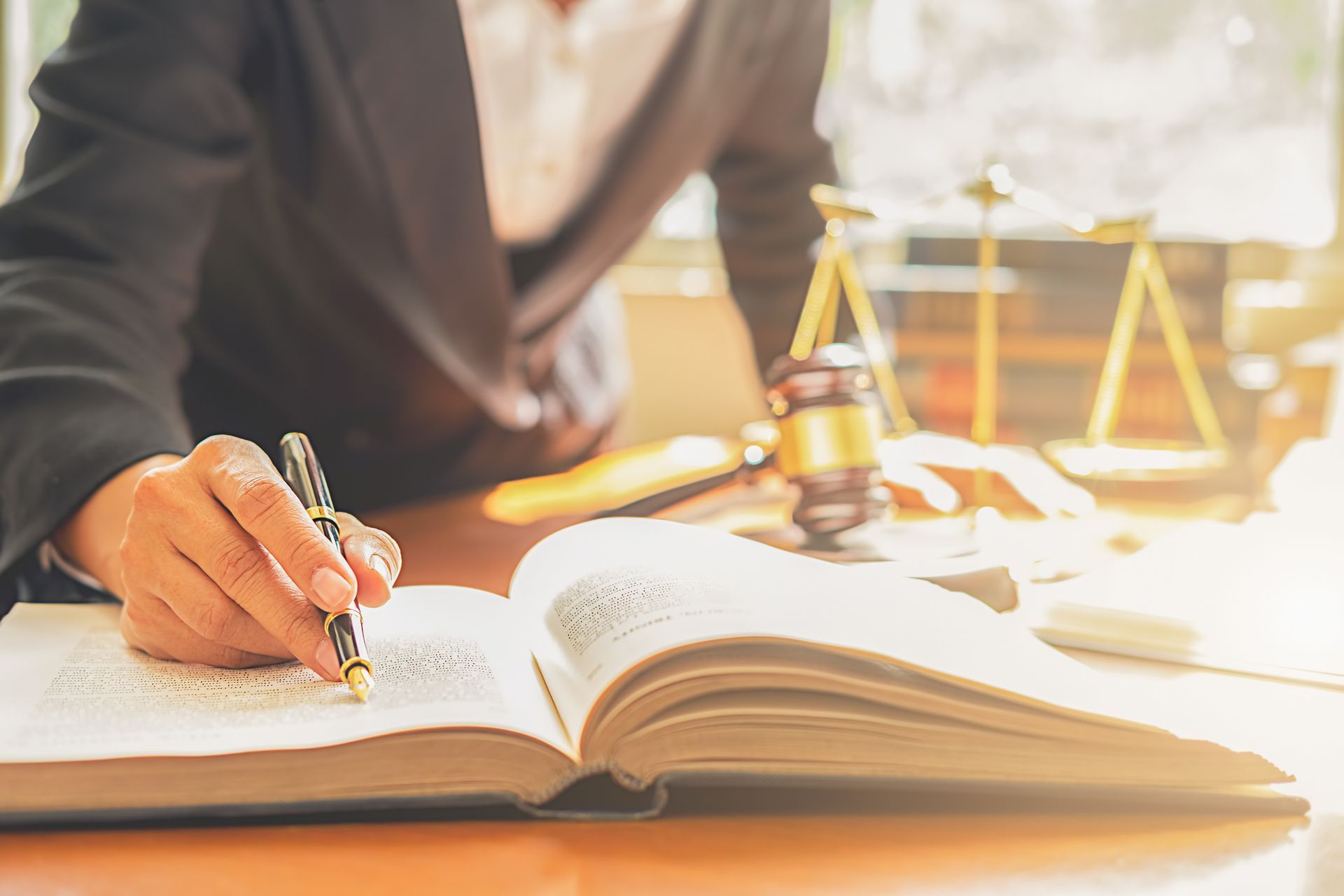 A woman is sitting at a desk writing in a book.
