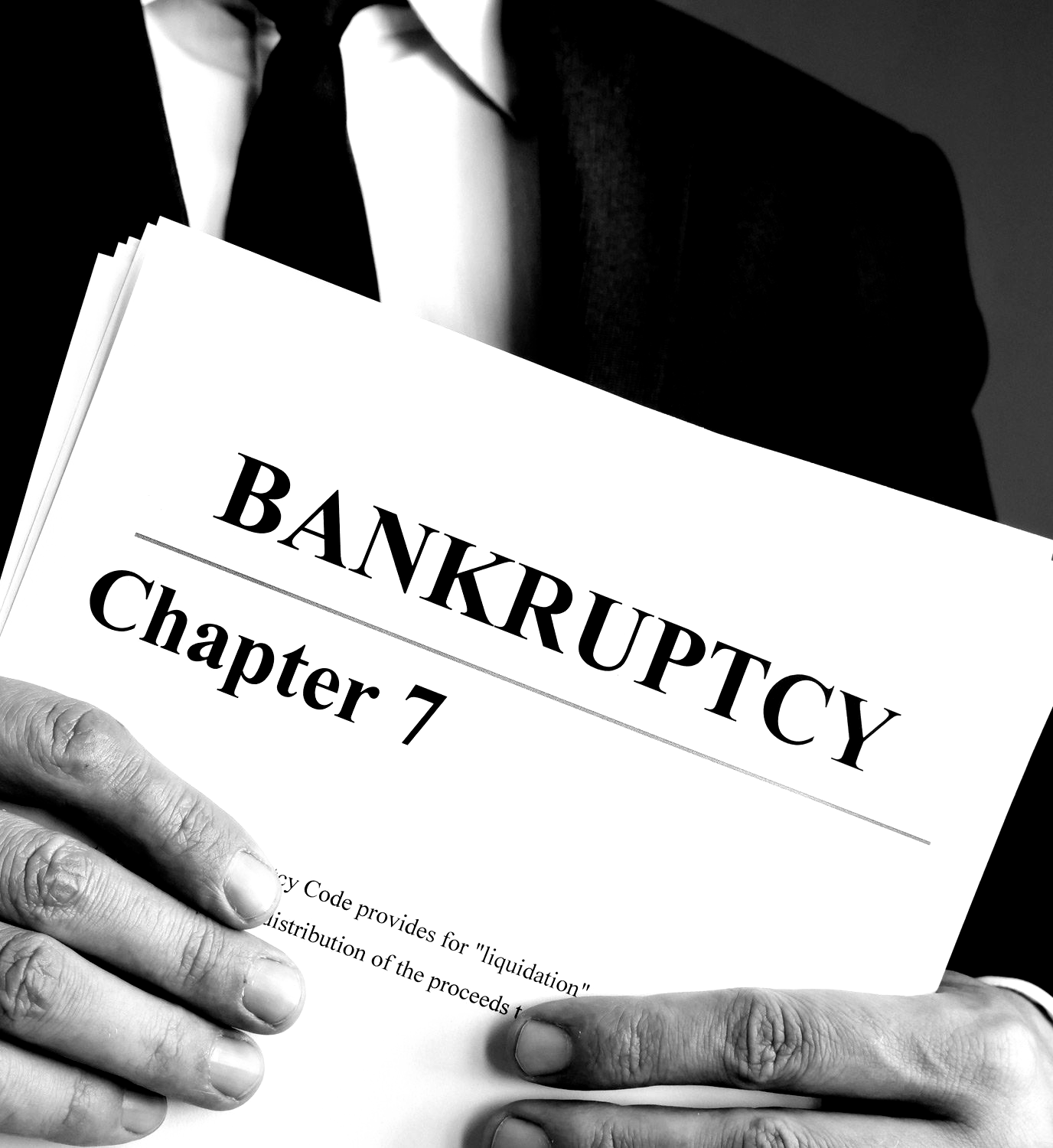 A man is holding a book titled bankruptcy chapter 7.