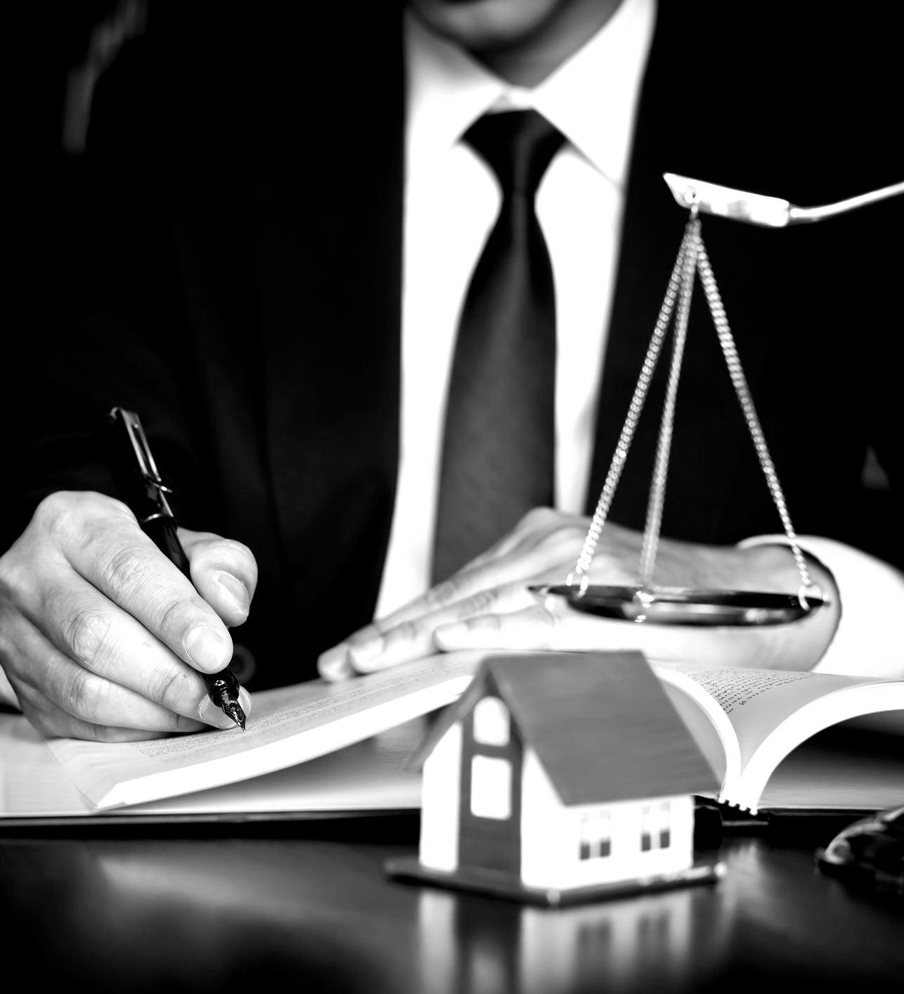 A man in a suit and tie is writing on a piece of paper