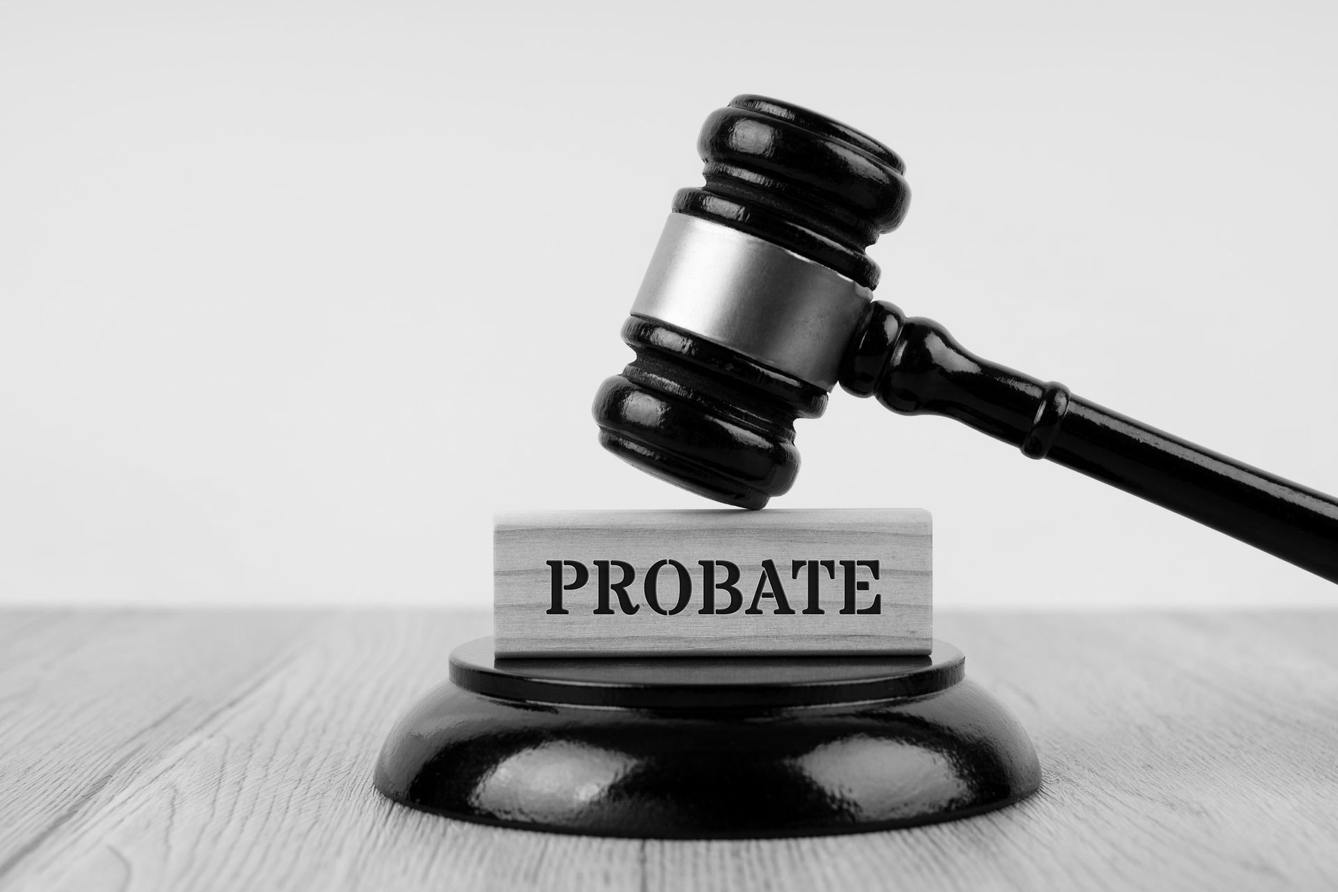 A judge 's gavel is sitting on top of a wooden block with the word probate written on it.