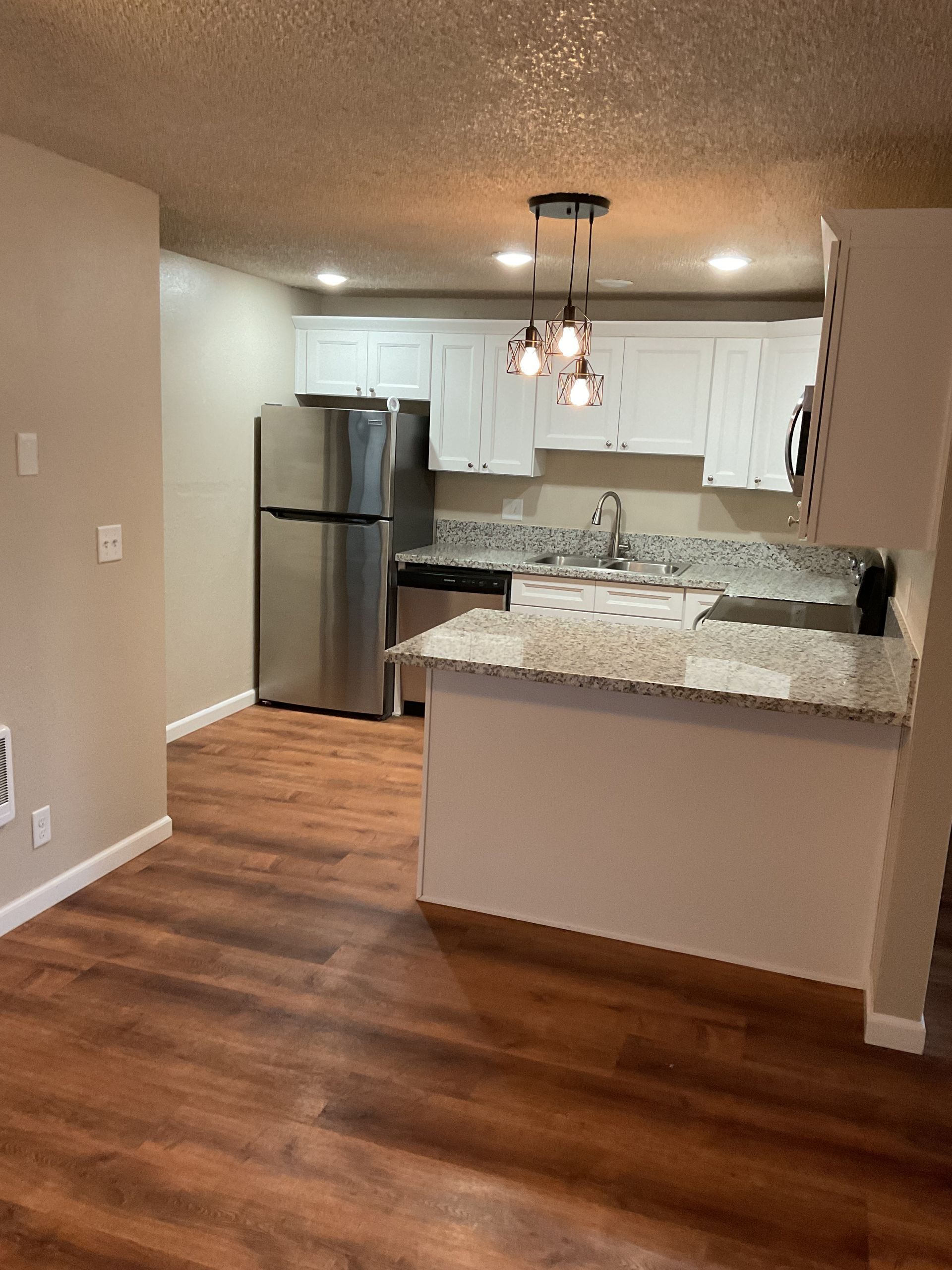 Kitchen with white cabinets, stainless steel appliances, and granite countertops.