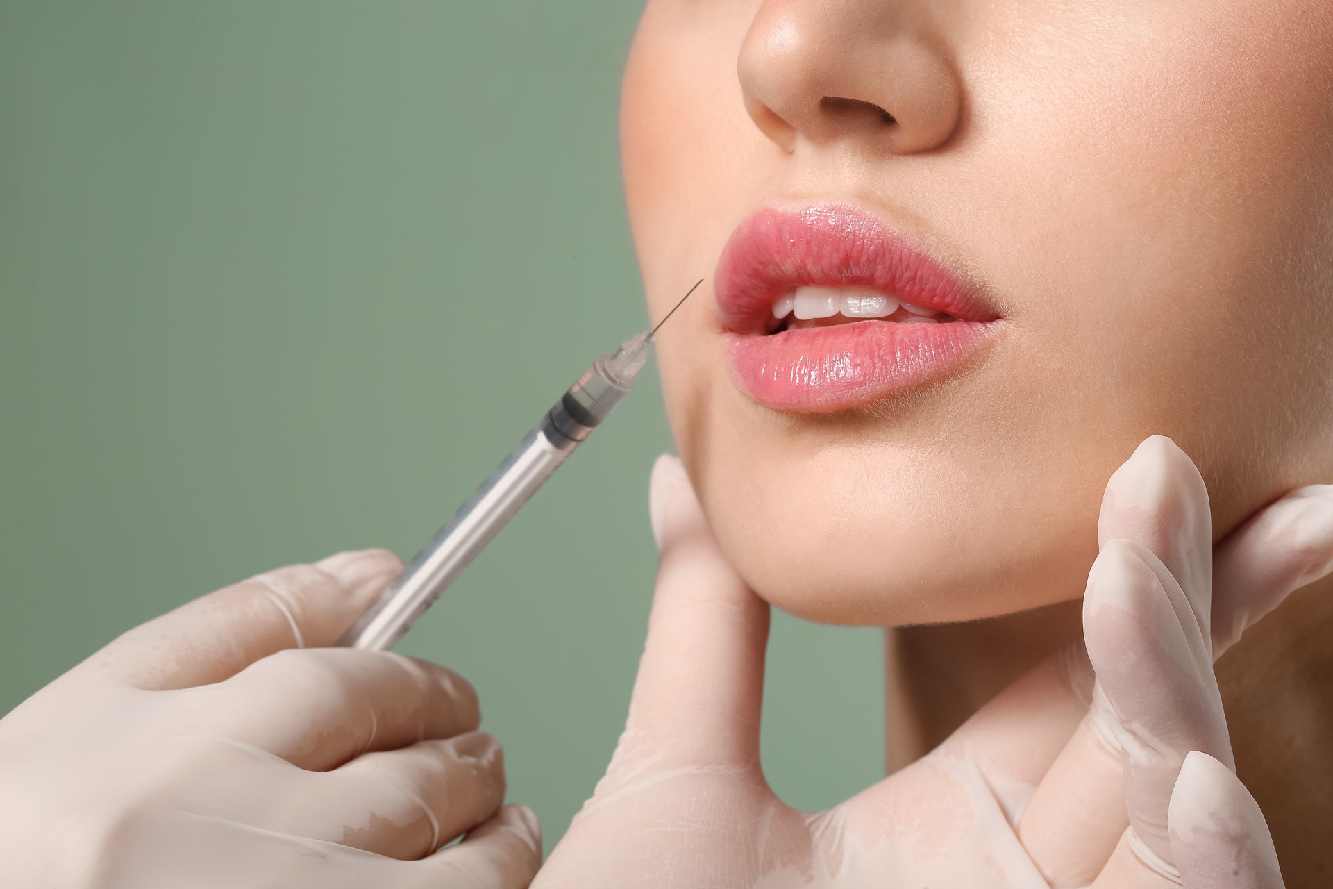 A woman is getting a botox injection in her lips.