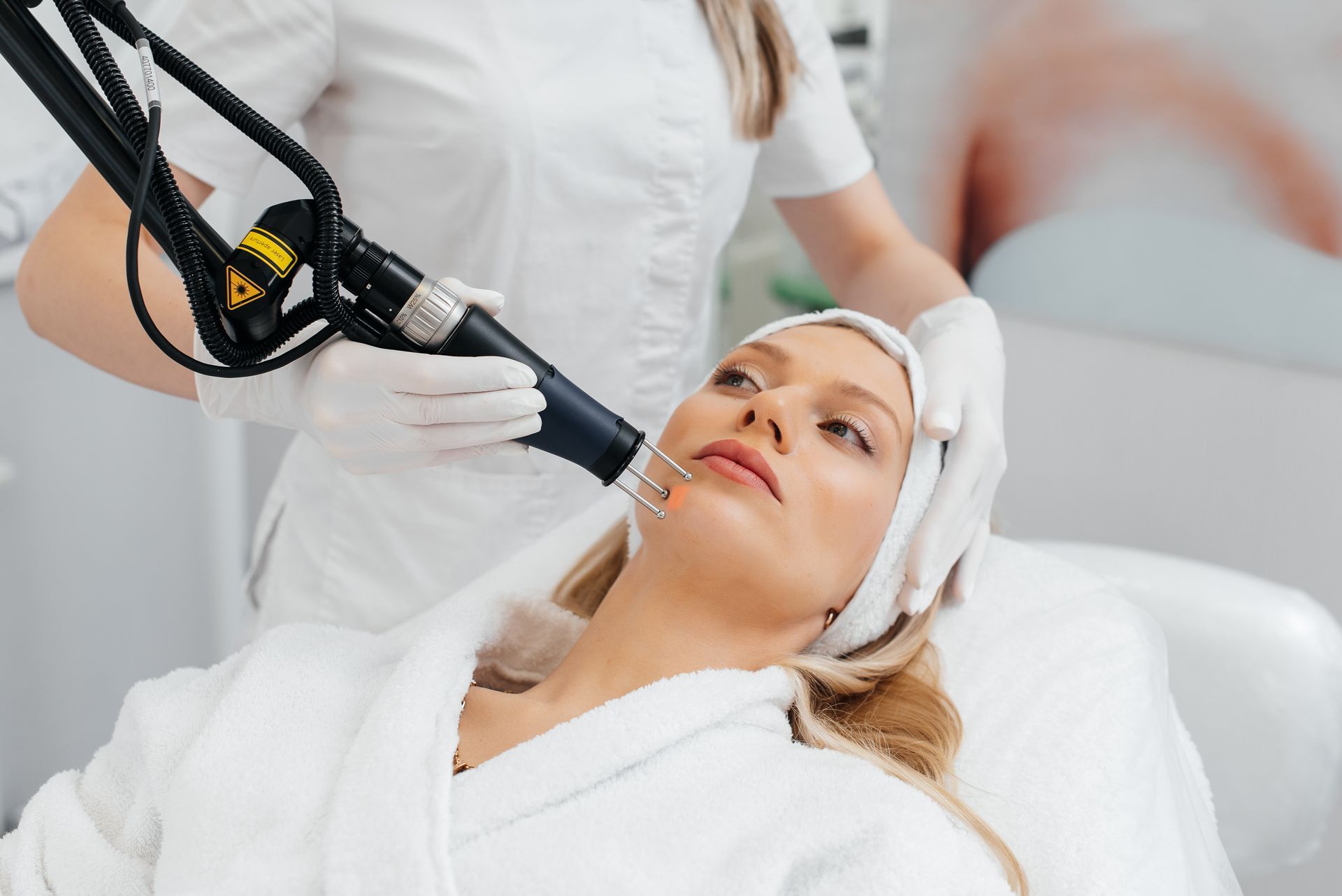A woman is getting a laser treatment on her face.