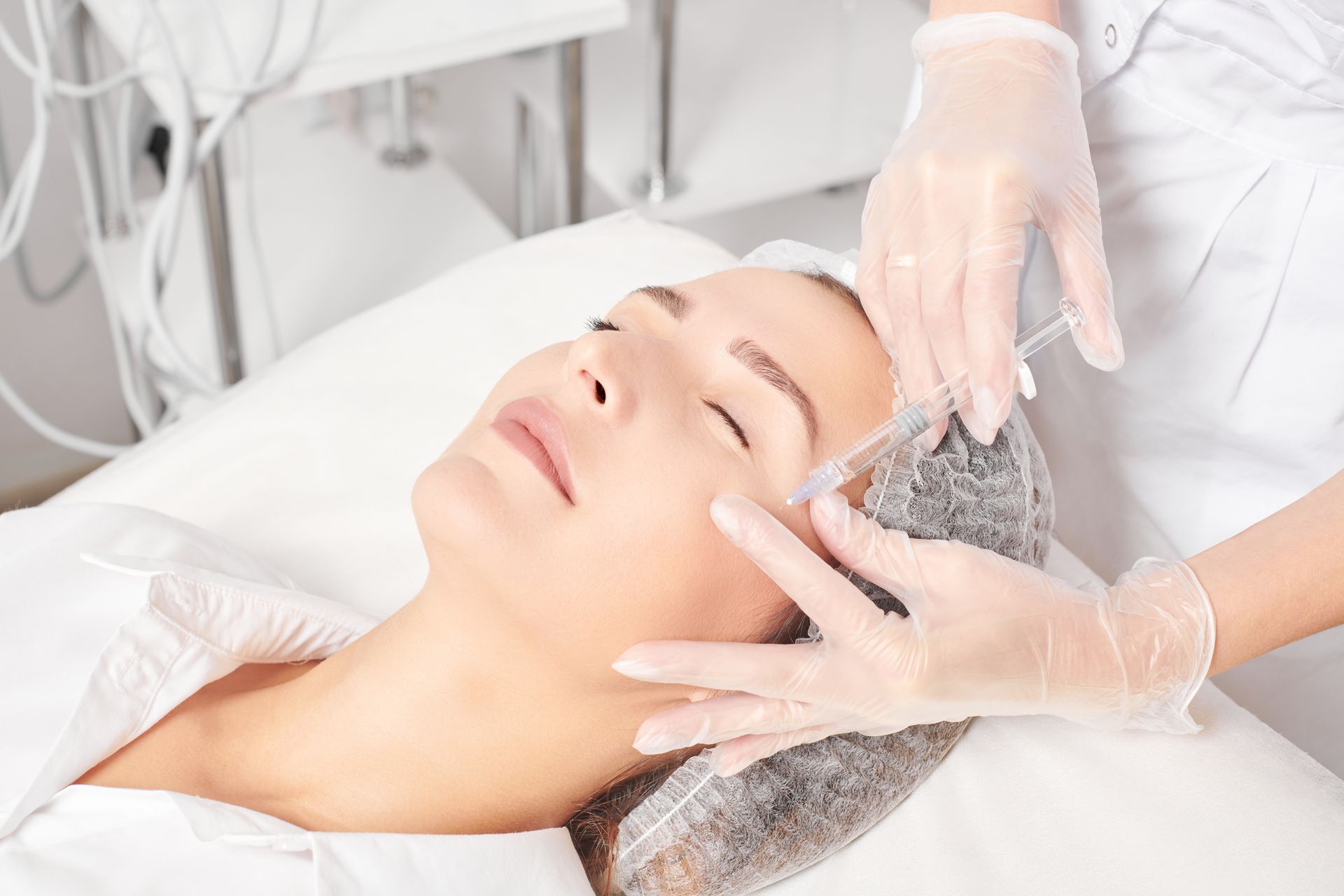 A woman is getting an injection in her face in a beauty salon.