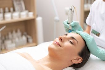 A woman is getting a facial treatment at a beauty salon.