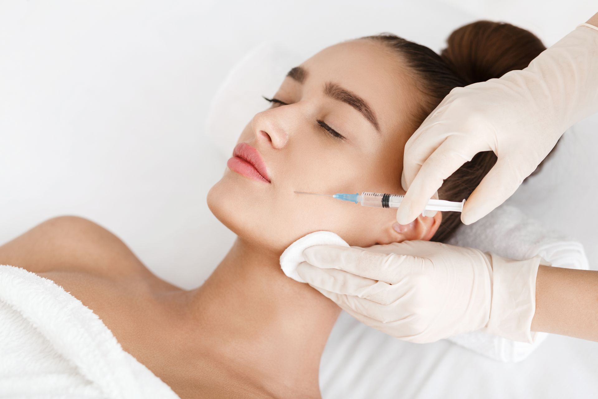 A woman is getting a botox injection in her face.