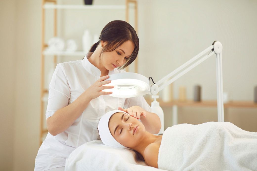 A woman is getting a facial treatment at a beauty salon.