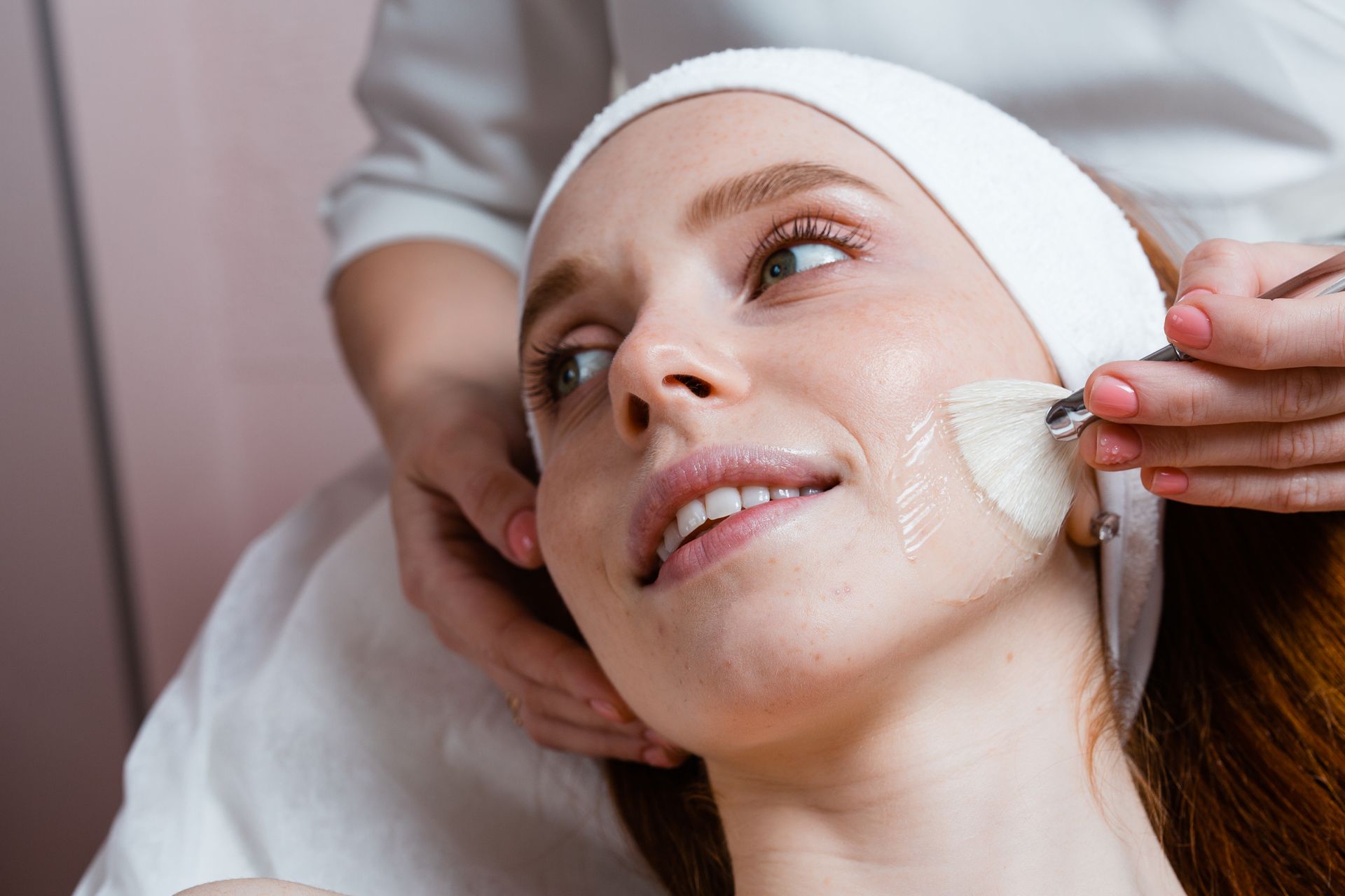 A woman is getting a facial treatment at a beauty salon.