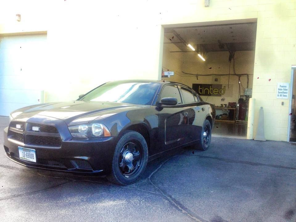 A black car is parked in front of a garage door.