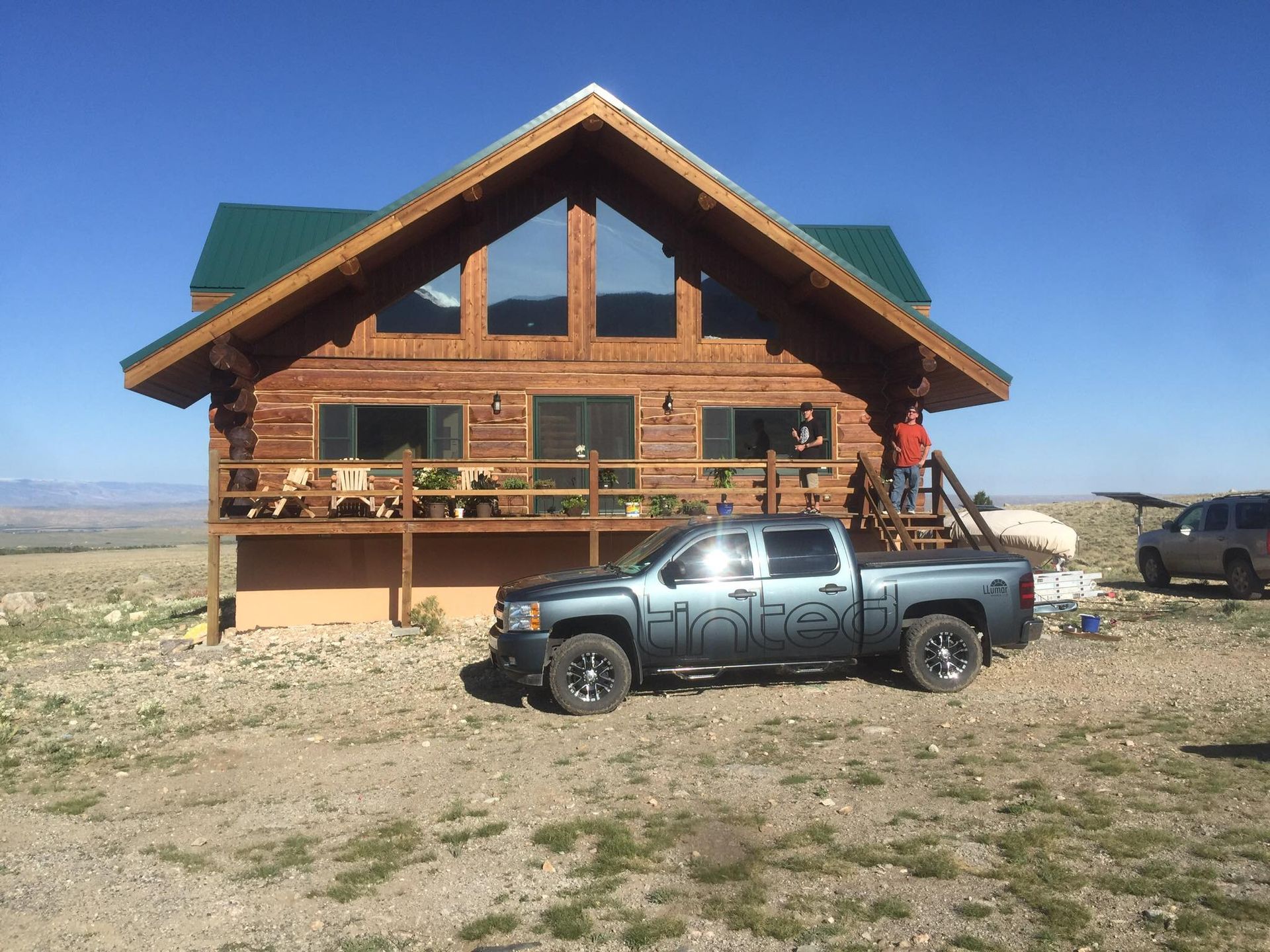 A truck is parked in front of a log cabin