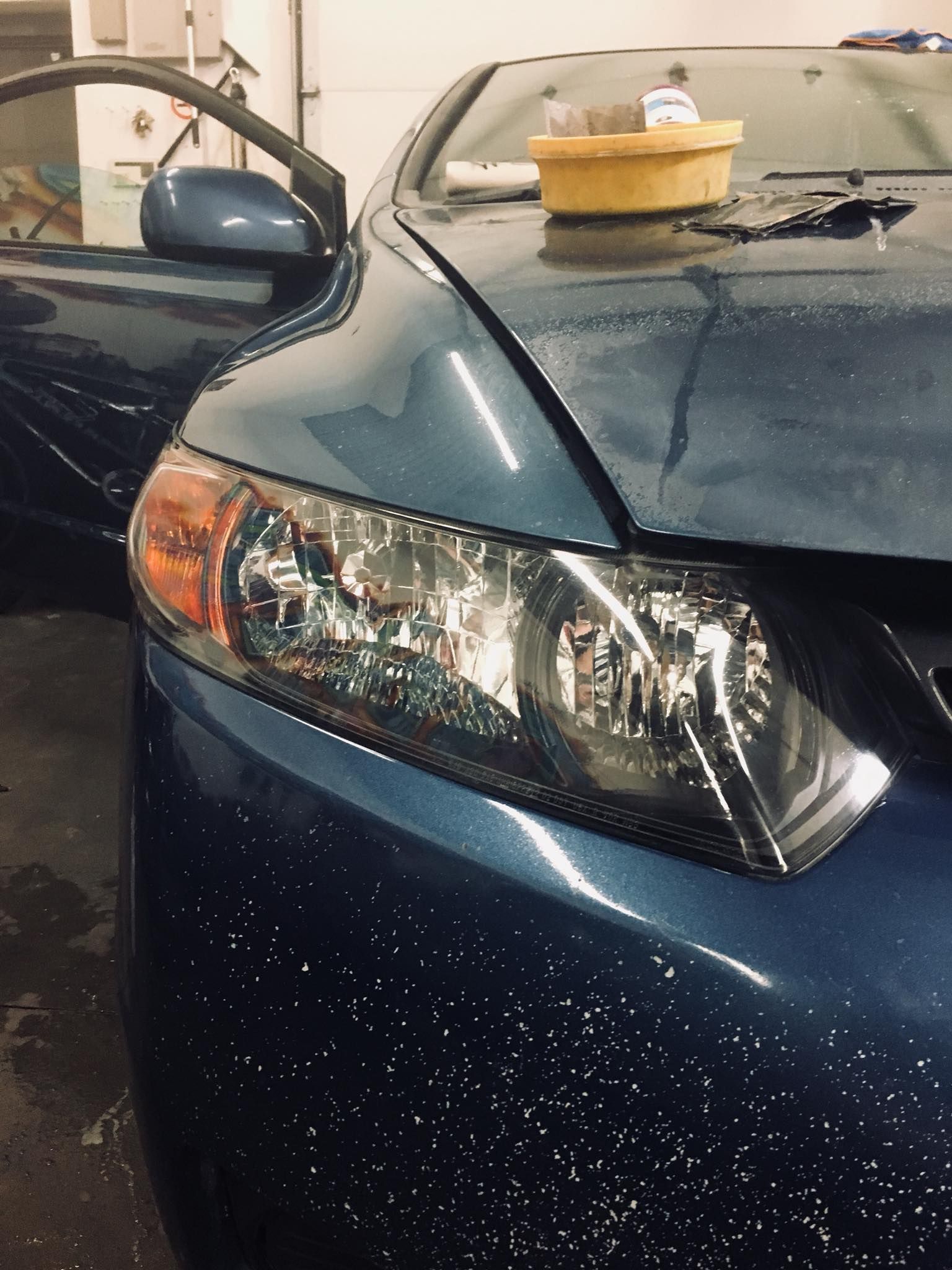 A blue car with a yellow bowl on the hood