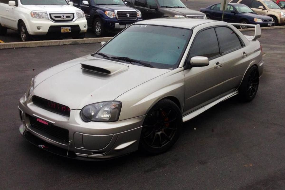 A silver subaru is parked in a parking lot