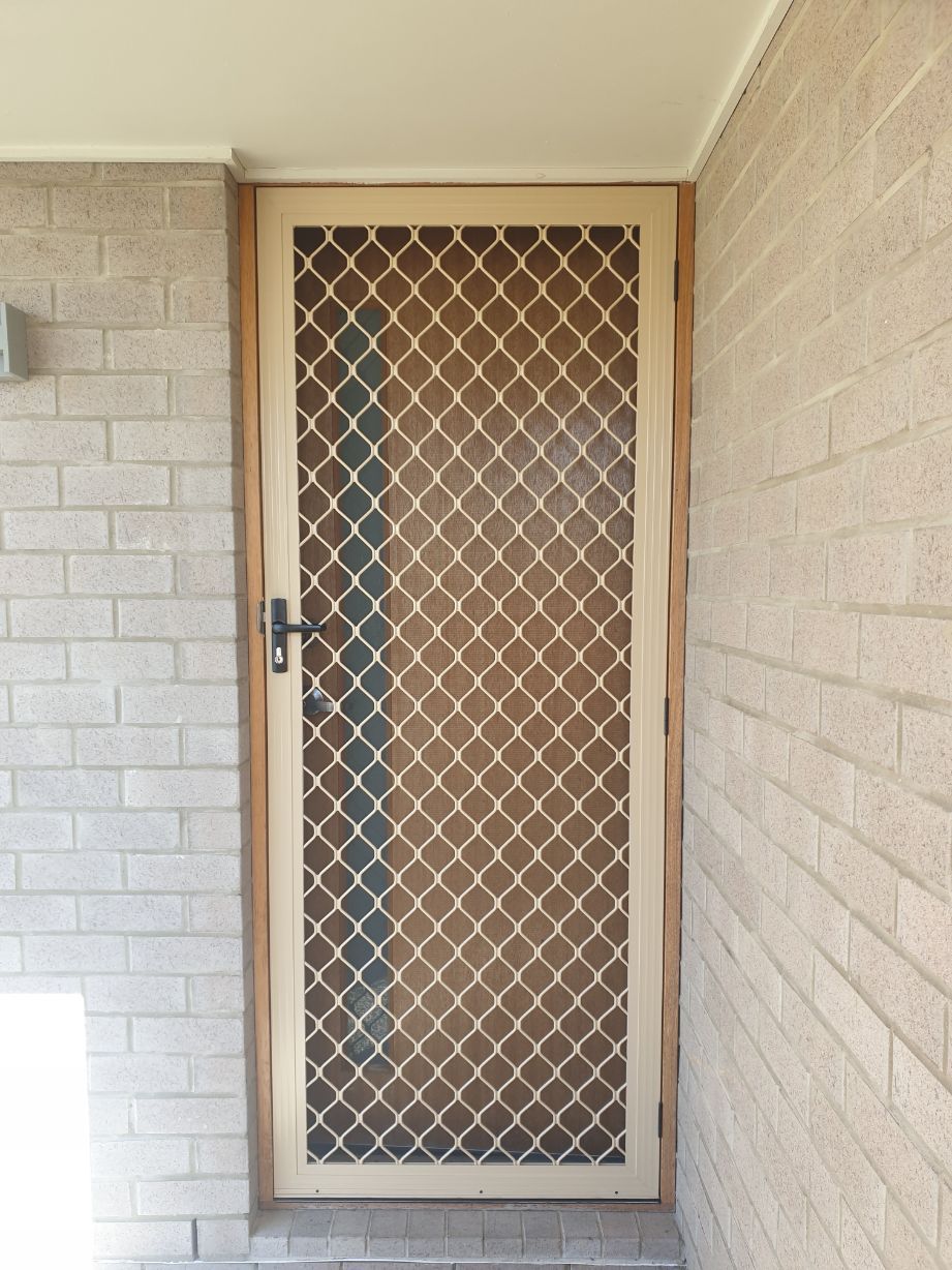 A Brick Wall With a Door That Has a Diamond Pattern on It  — Smart Screens Qld in Ormeau, QLD