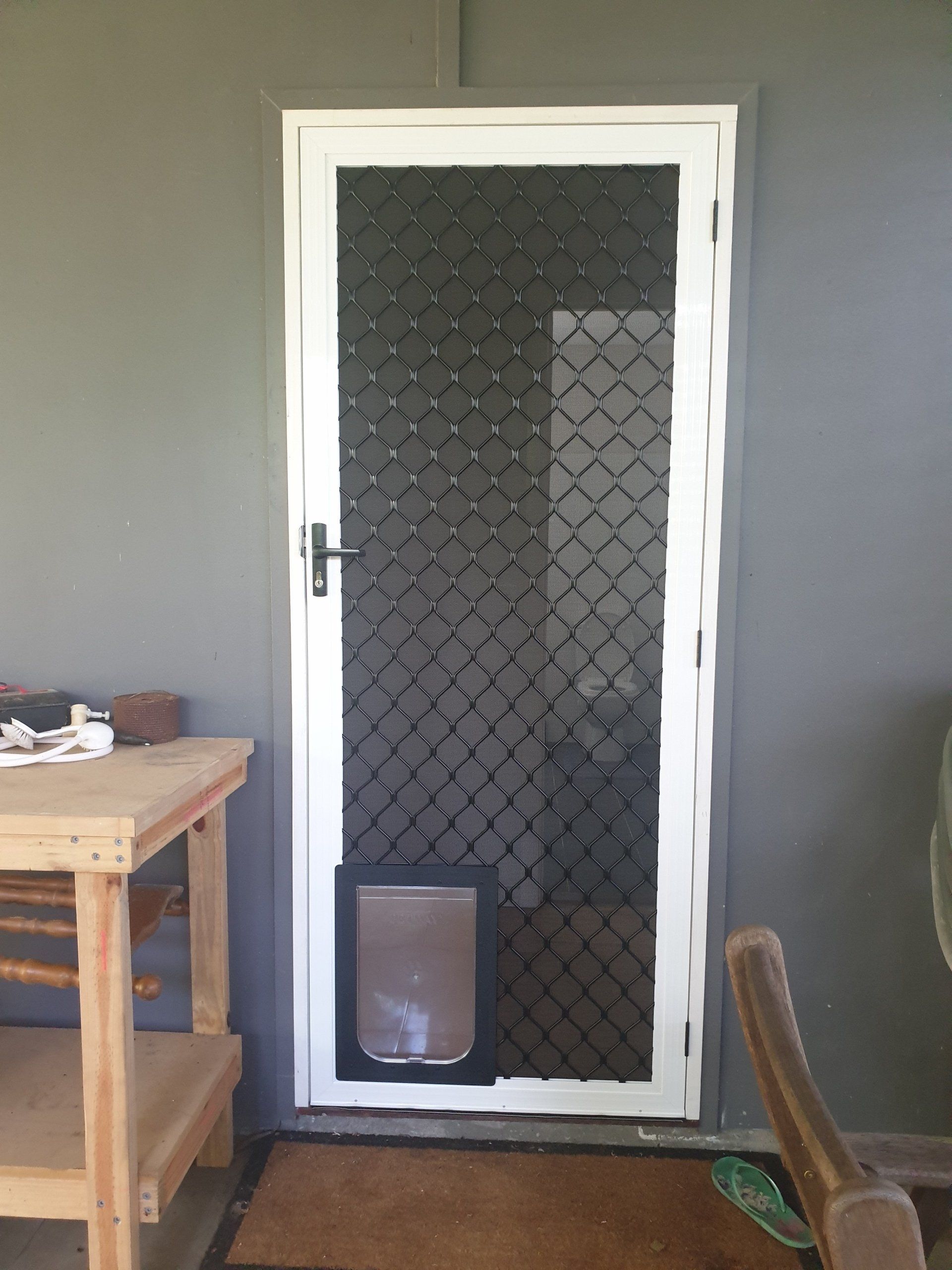 A White Door With a Dog Door in It is in a Room  — Smart Screens Qld in Ormeau, QLD