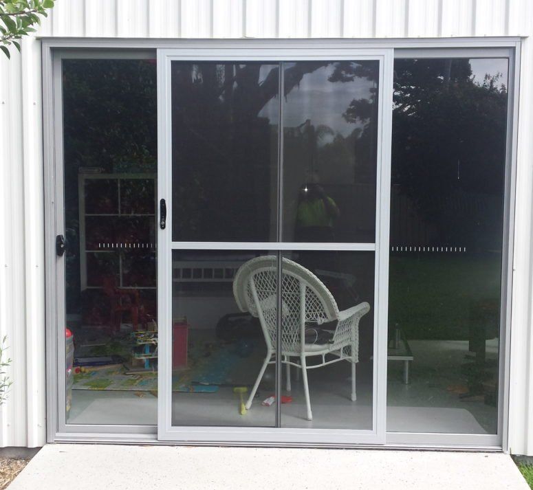 A Wicker Chair Sits in Front of a Sliding Glass Door