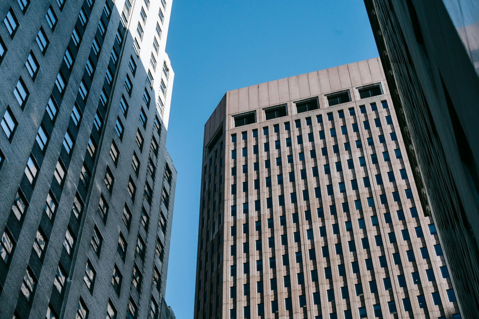 Skyscrapers against a bright blue sky; buildings with many windows.