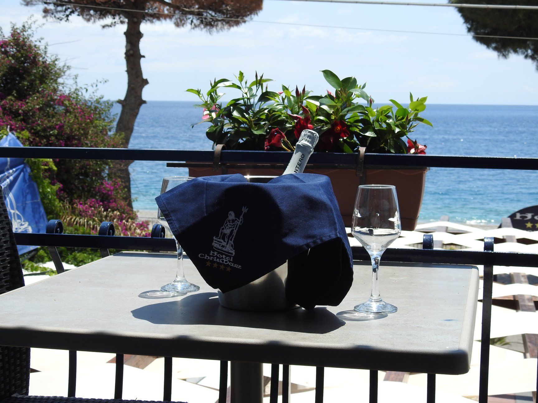 Un tavolo con sopra due bicchieri di vino e una bottiglia di champagne