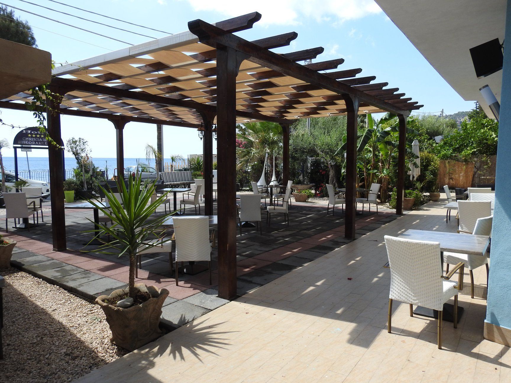 Un patio con tavoli e sedie sotto un pergolato