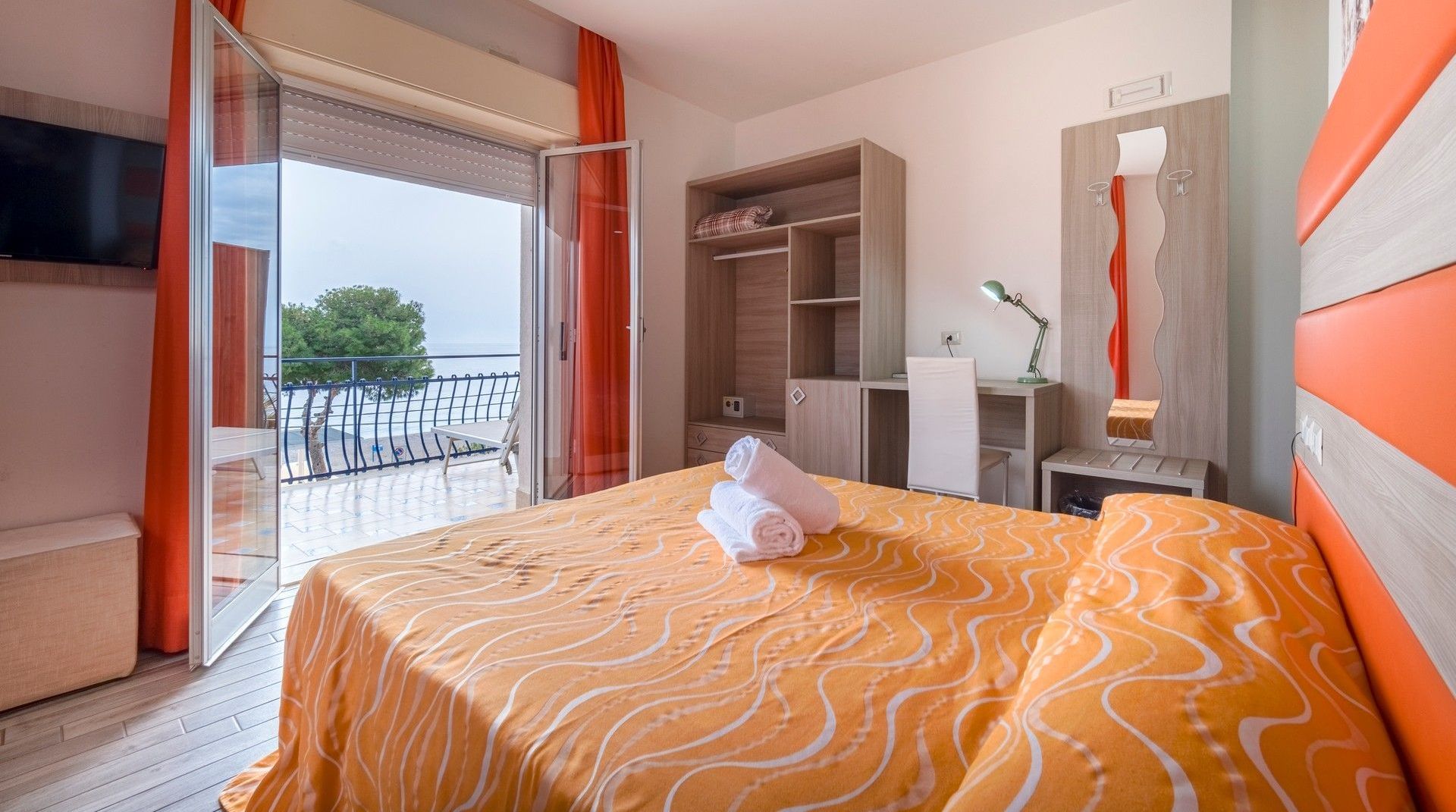 Una camera d'albergo con un letto king size e un balcone.