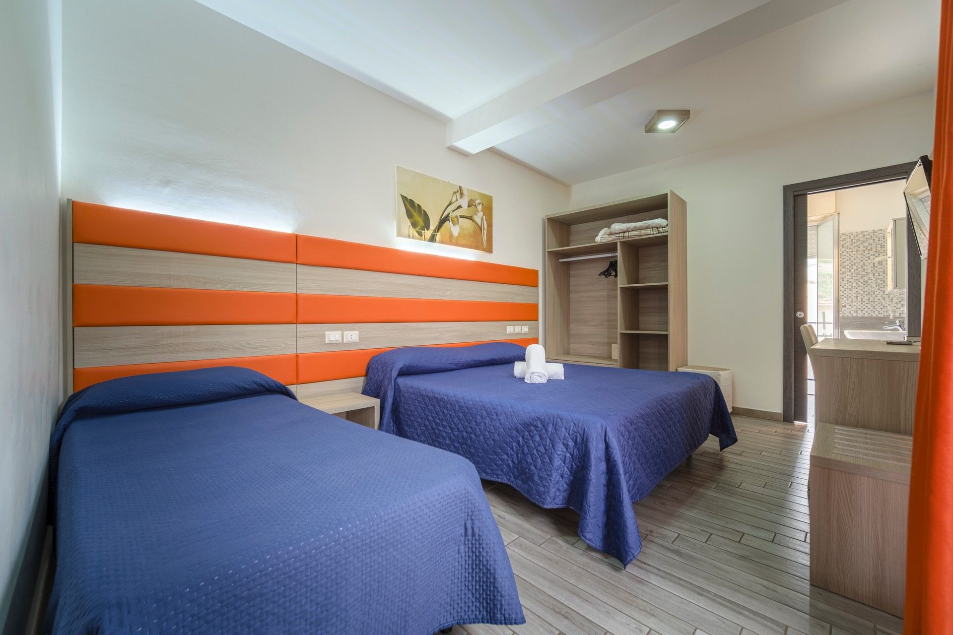 Una camera d'albergo con due letti e un armadio.