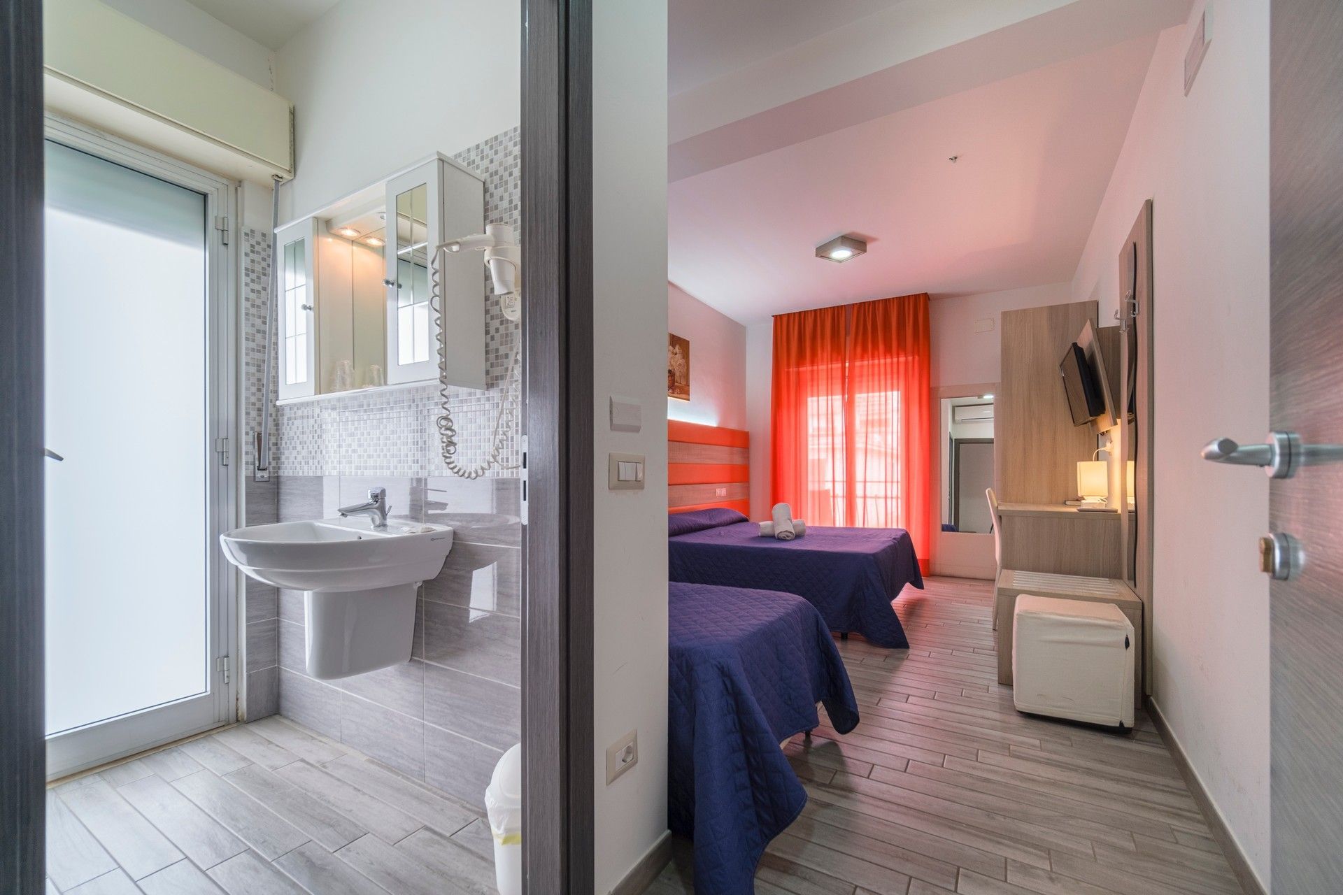 A hotel room with two beds and a sink