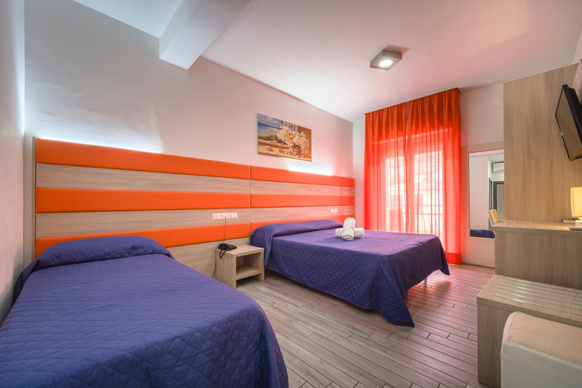 A hotel room with two beds and a television set.