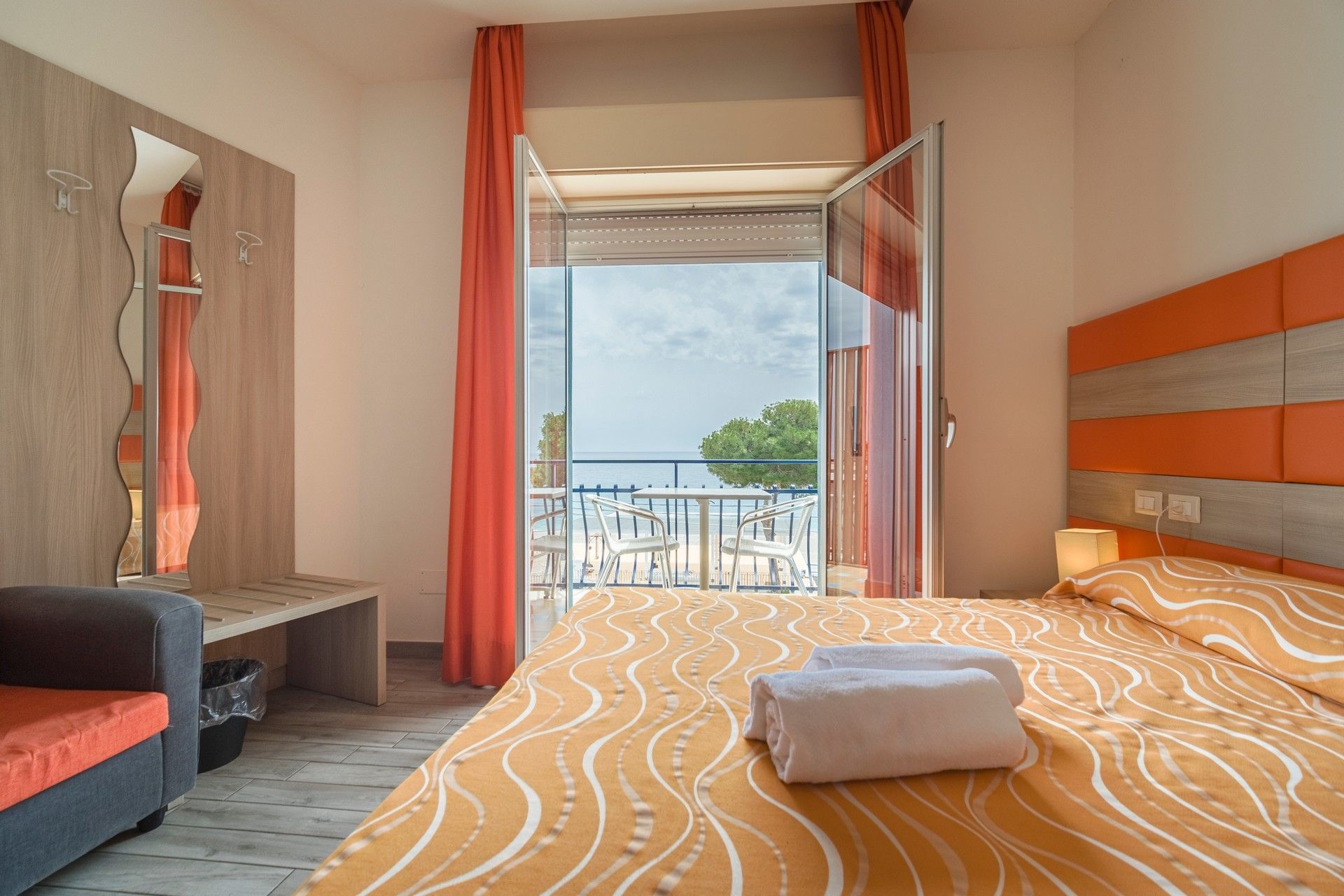 Una camera d'albergo con un letto, un divano e un balcone.